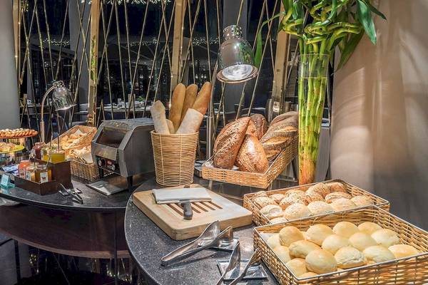 Frühstücksbuffet im Chatrium Hotel Riverside Bangkok mit verschiedenen Brotsorten, Gebäck und Dekoration.