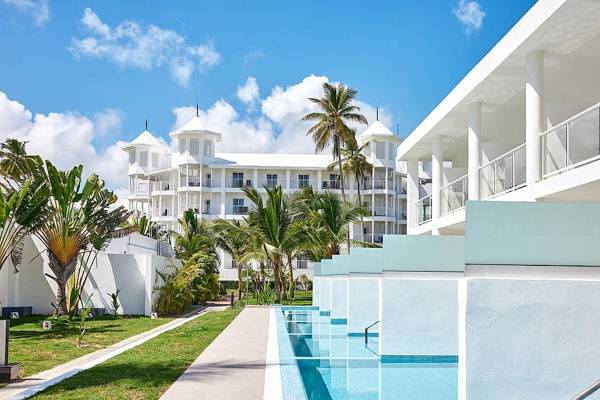 Außenbereich des Riu Palace Macao Hotels mit Swimmingpool und weißen Gebäuden.