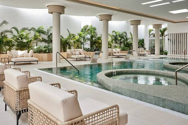 Innenpoolbereich im RIU Palace Macao mit Lounge-Sesseln und Pflanzen.