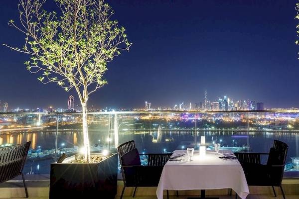 Dinner-Tisch auf der Terrasse mit Blick auf die Stadt bei Nacht, Al Bandar Rotana Hotel