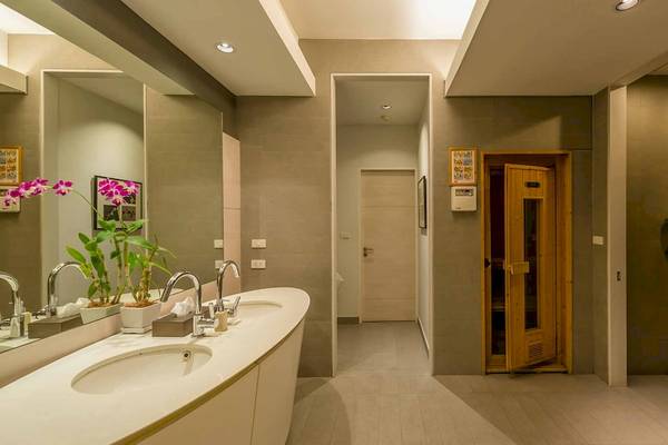 Das Badezimmer im Chatrium Hotel Riverside Bangkok mit zwei Waschbecken, Spiegel und einem offenen Saunaraum.