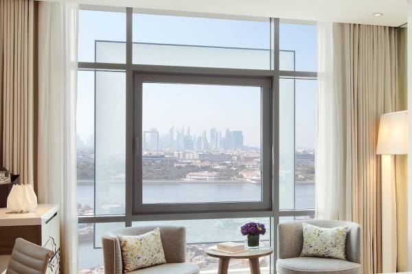 Zimmer im Al Bandar Rotana Hotel mit Blick auf die Stadt und Wasser.