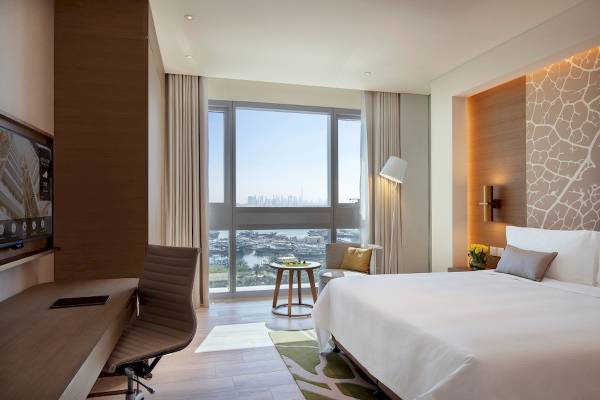 Innenansicht eines Hotelzimmers im Al Bandar Rotana mit Blick auf die Stadt.