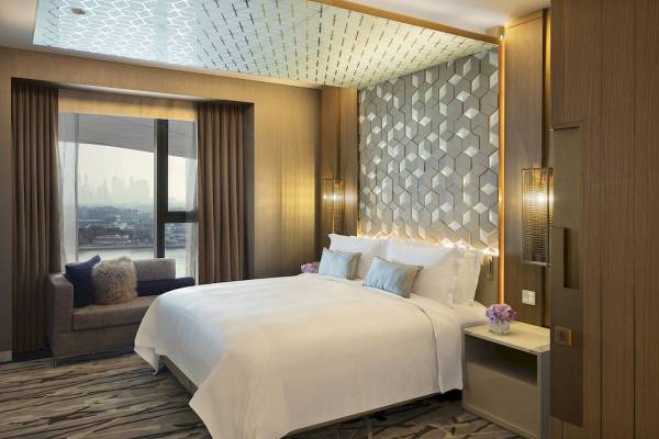 Schlafzimmer im Al Bandar Rotana Hotel mit Blick auf die Stadt.