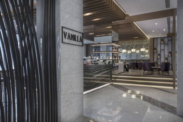 Innenbereich des Al Bandar Rotana Hotels mit der Vanilla Bar im Vordergrund.