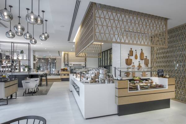 Innenbereich des Al Bandar Rotana Hotels mit moderner Einrichtung, Buffet und Tischdekoration.
