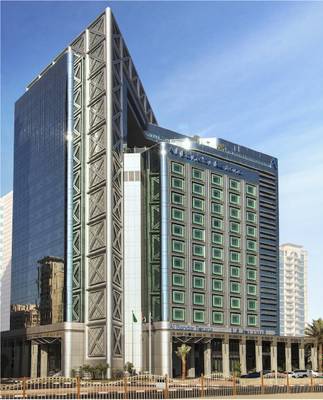 Außenansicht des Al Bandar Rotana Hotels mit moderner Architektur und vielen Fenstern.