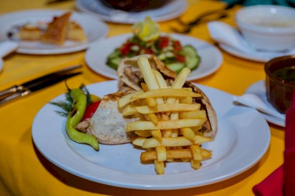 Essen auf Tellern im Golden Beach Resort, einschließlich Salat, Pommes und einem Gericht.
