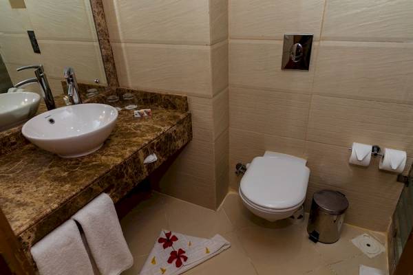 Badezimmer im Golden Beach Resort mit Waschbecken, Spiegel und Toilette