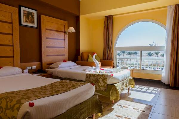 Doppelzimmer im Golden Beach Resort mit zwei Betten, Blick auf Palmen und Meer