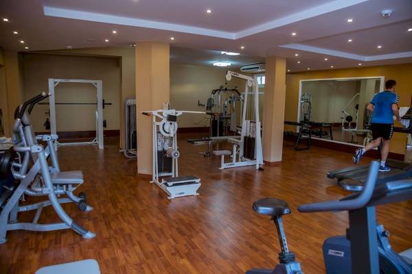 Fitnesscenter im Golden Beach Resort mit einem Mann auf dem Laufband.