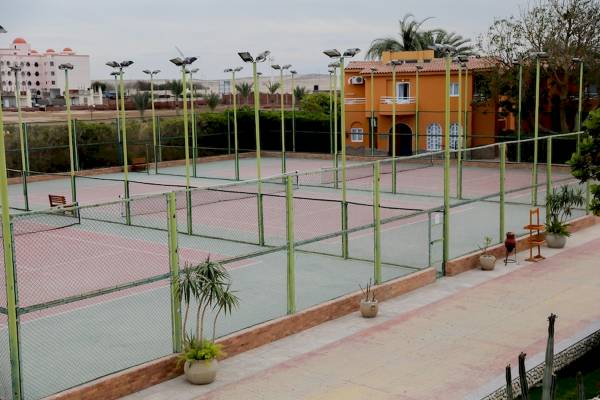 Tennisplatz des Golden Beach Resorts mit grünen Zäunen und gelben Säulen