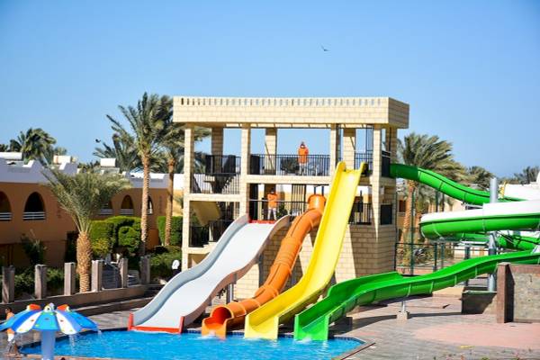 Mehrere Wasserrutschen im Freien neben einem Pool im Golden Beach Resort.