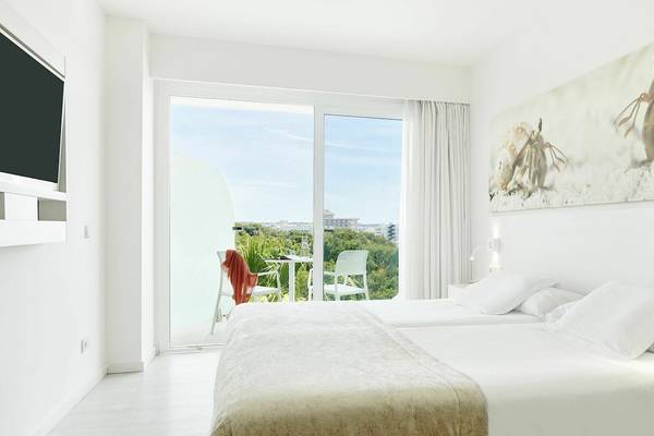 Zimmer mit zwei Betten und Aussicht auf einen Garten und eine Stadt