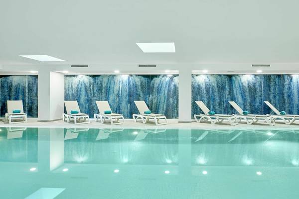 Innenpool im Iberostar Cristina Hotel mit weißen Liegen und blauen Wänden