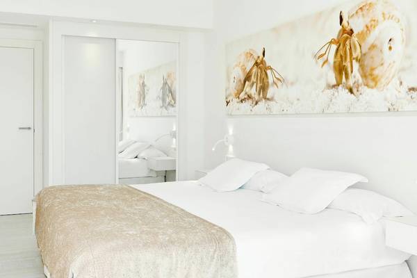 Weißes Schlafzimmer mit modernen Möbeln und Kunstwerken in einem Hotelzimmer.