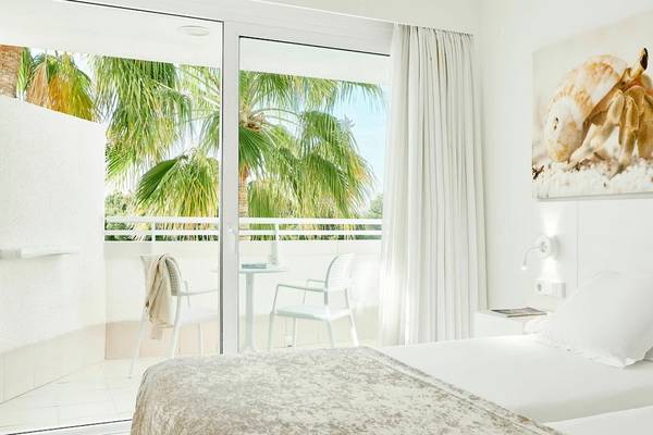 Zimmer im Iberostar Cristina Hotel mit Terrasse und Ausblick auf Palmen und Meer.