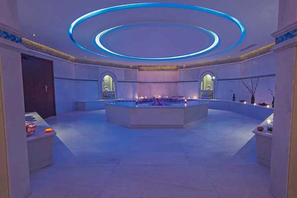 Innenansicht des Premier Le Reve Hotel & Spa mit einer runden Poollandschaft und blauer Beleuchtung.