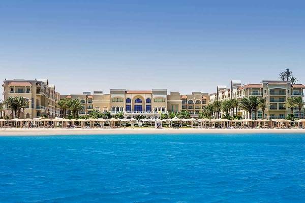 Außenansicht des Premier Le Reve Hotel & Spa am Strand mit vielen Sonnenschirmen.
