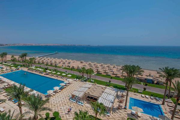 Außenbereich des Premier Le Reve Hotel & Spa mit Pools, Liegestühlen und Palmen