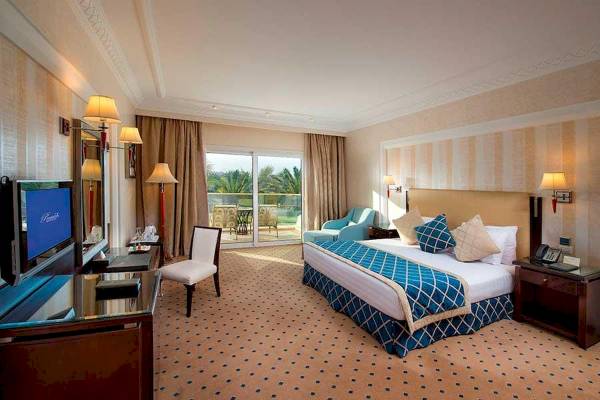 Luxuriöses Zimmer im Premier Le Reve Hotel mit großem Bett und Fernseher.