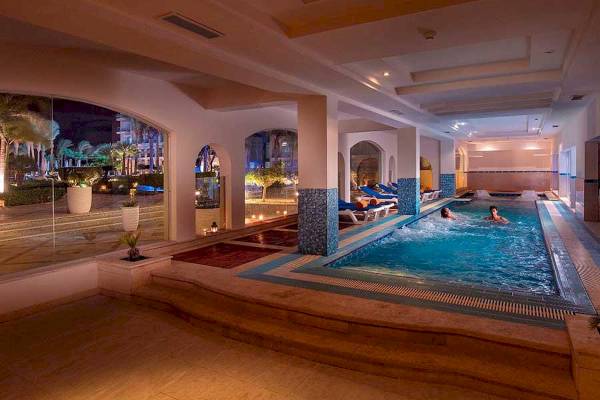 Nachtaufnahme des beleuchteten Innenpools des Premier Le Reve Hotel & Spa