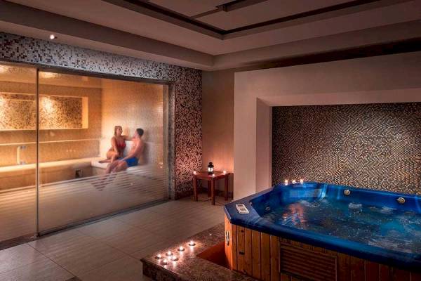 Jacuzzi im Premier Le Reve Hotel & Spa mit zwei Personen im Hintergrund.