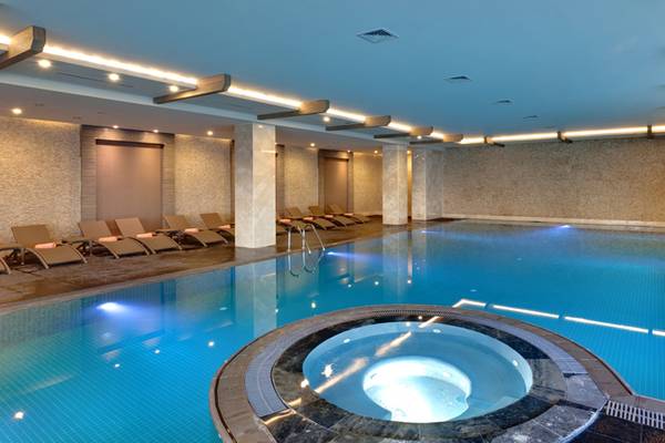 Innenpool im Sherwood Dreams Resort mit mehreren Sonnenliegen und einem Whirlpool.
