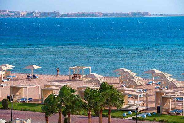 Aussicht auf den Strand des Premier Le Reve Hotel & Spa mit Sonnenschirmen und Liegen.