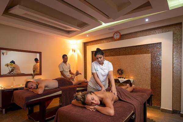 Massage Behandlung im Premier Le Reve Hotel & Spa mit zwei Frauen und einem Mann, der eine Massage genießt.