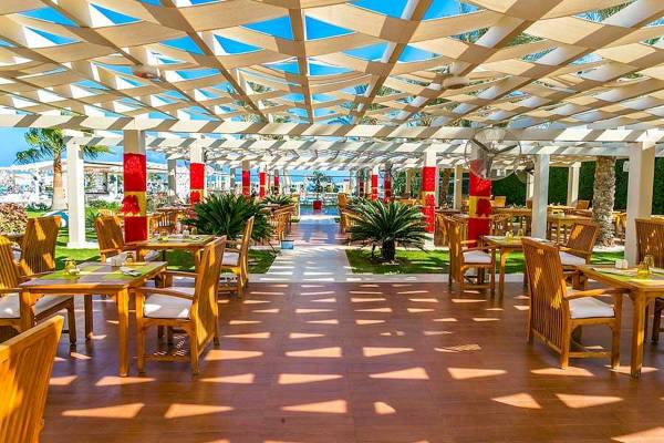 Terrasse des Premier Le Reve Hotel & Spa mit Tischen, Stühlen und Pflanzen