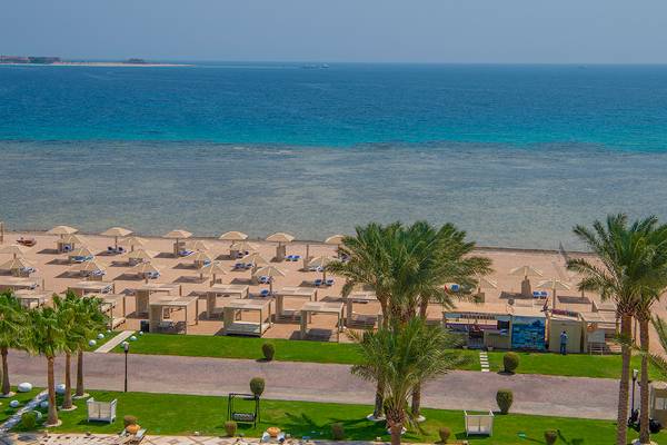 Ausblick auf den Strand des Premier Le Reve Hotel & Spa mit vielen Sonnenschirmen und Palmen