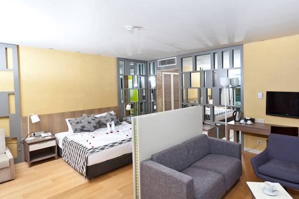 Hotelzimmer von Sherwood Dreams Resort mit einem Bett, einem Schreibtisch, einem Fernseher und einem Wohnzimmerbereich.