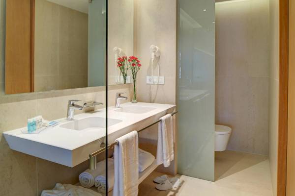 Badezimmer im Hipotels Gran Playa de Palma mit zwei Waschbecken, Handtüchern und Toilette.