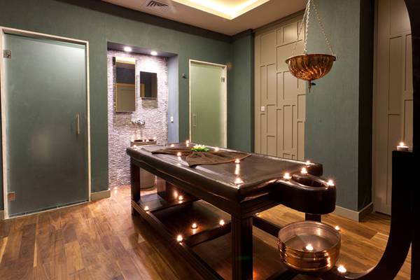 Massagesalon im Sherwood Dreams Resort mit Holzboden und grünen Wänden.