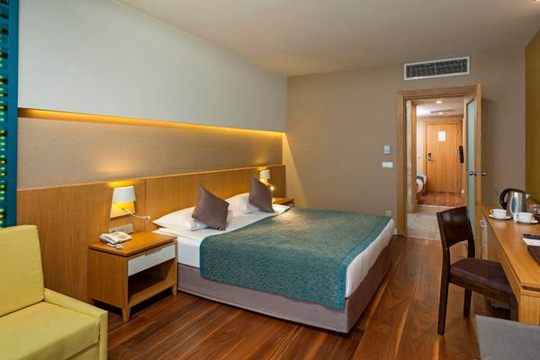 Innenansicht eines Hotelzimmers im Sherwood Dreams Resort mit Bett, Schreibtisch und Fernseher.