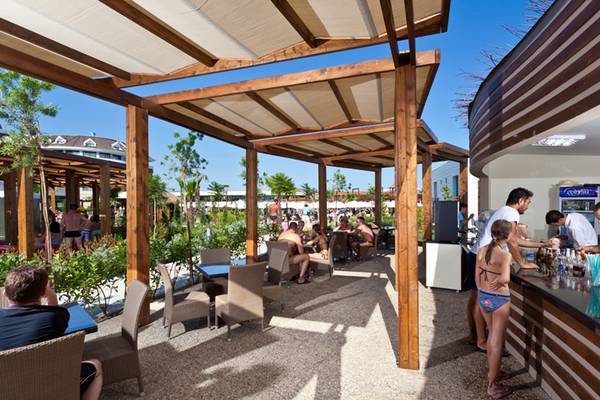 Terrasse des Sherwood Dreams Resorts mit Gästen, Bar und Sonnenschutz