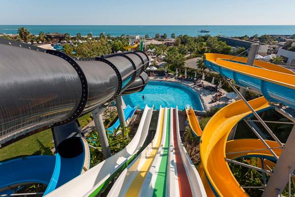Mehrere bunte Wasserrutschen am Sherwood Dreams Resort mit Blick auf das Meer und den Pool.