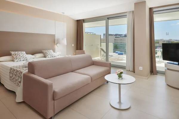 Suite Zimmer im Hipotels Gran Playa de Palma mit Bett, Sofa, Tisch und Fernseher.