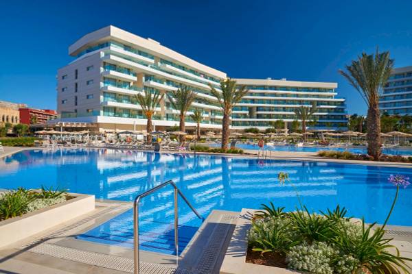 Ein Swimmingpool mit Loungestühlen vor dem Hipotels Gran Playa de Palma Hotel.