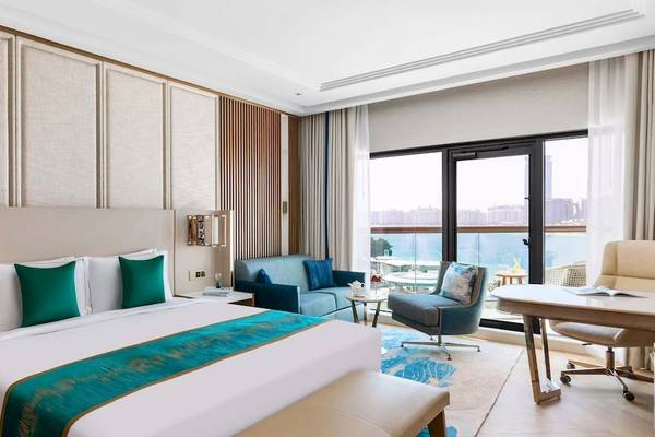 Hotelzimmer im Taj Exotica Resort & Spa The Palm Dubai mit Bett, Couch, Schreibtisch und Meerblick