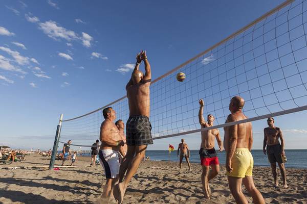 Gruppe von Männern spielt Volleyball auf dem Strand am Sherwood Dreams Resort.