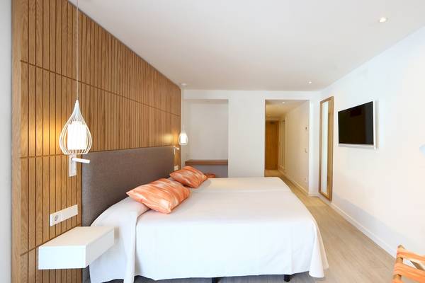 Doppelbett-Zimmer im Iberostar Playa de Muro Hotel mit modernem Design und Holzwand.