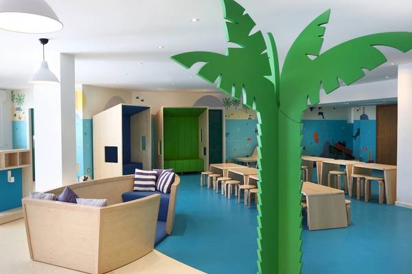 Kinderbereich im Iberostar Playa de Muro Hotel mit blauem Boden, bunten Wänden und Sitzmöbeln.