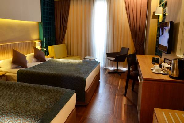 Doppelzimmer im Sherwood Dreams Resort mit zwei Betten, Schreibtisch, Fernseher und Möbeln.