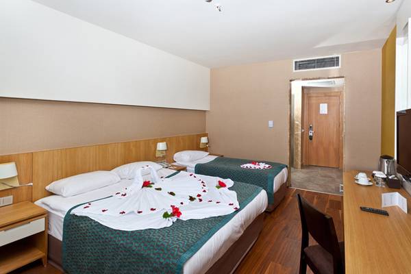 Doppelzimmer im Sherwood Dreams Resort Hotel mit Rosenblättern auf dem Bett.