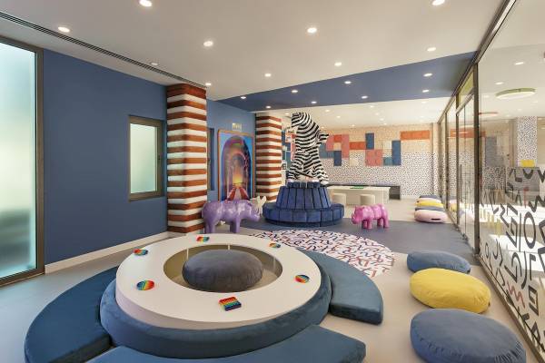 Innenraum des Cullinan Belek Hotels mit bunten Sofas, Kissen und Spielzeug.