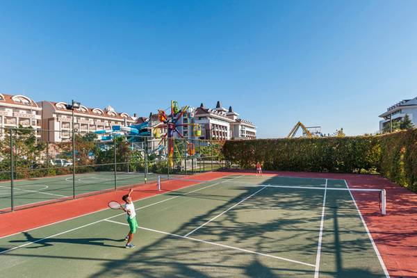 Tennisplatz im Sherwood Dreams Resort mit einem Spieler, der einen Ball schlägt.