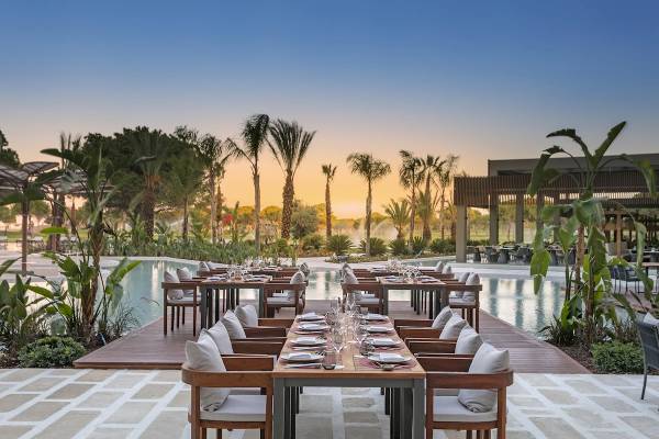 Terrassenrestaurant am Pool des Cullinan Belek Hotels mit abendlicher Atmosphäre.