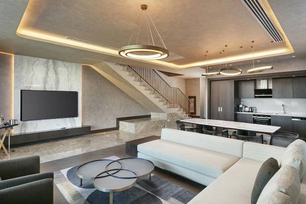 Innenbereich des Cullinan Belek Hotels mit Wohnzimmer, Essbereich und Treppe.